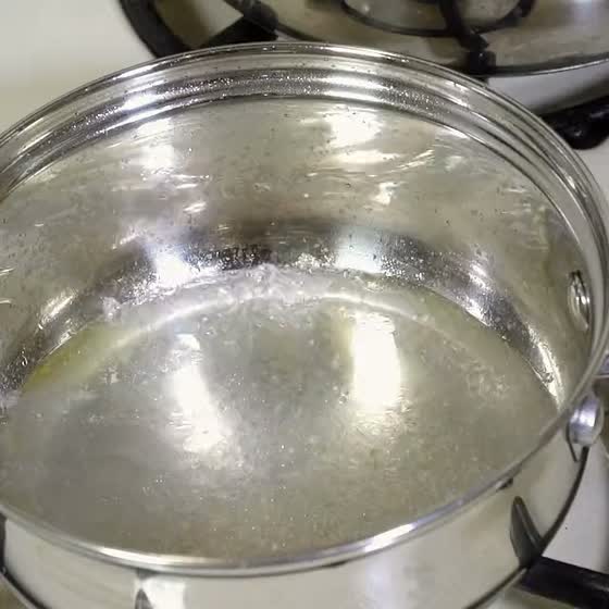 Chicken broth warming in a steel pan on the stove