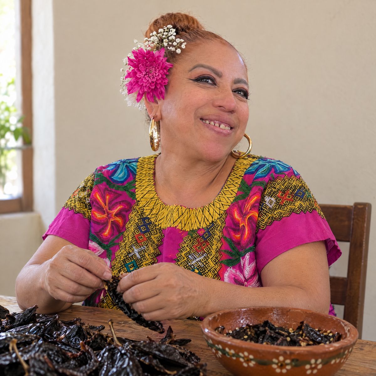 Elisa Beristain, owner of Halietza, sorting dried chiles at her kitchen table