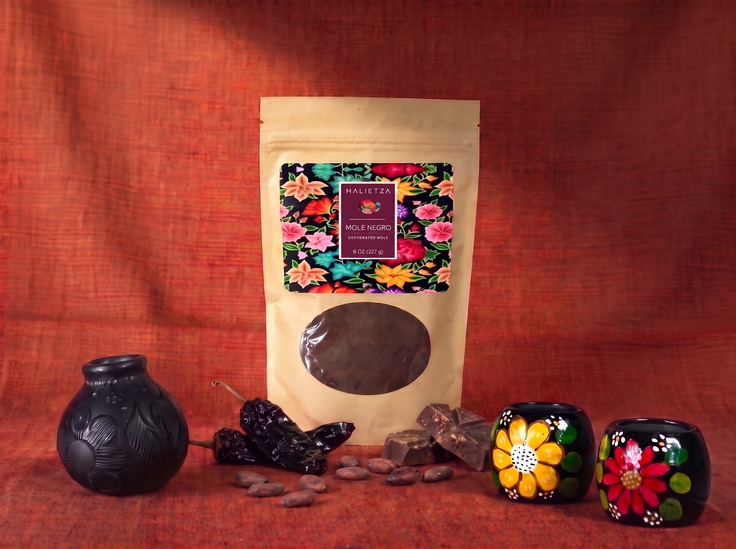 A pouch of Halietza Mole Negro beside a dish of dark mole negro sauce